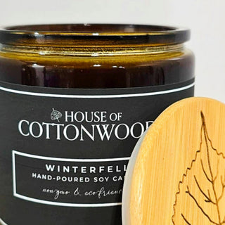 Candle jar with bamboo lid featuring 'House of Cottonwood' branding on a bamboo lid.